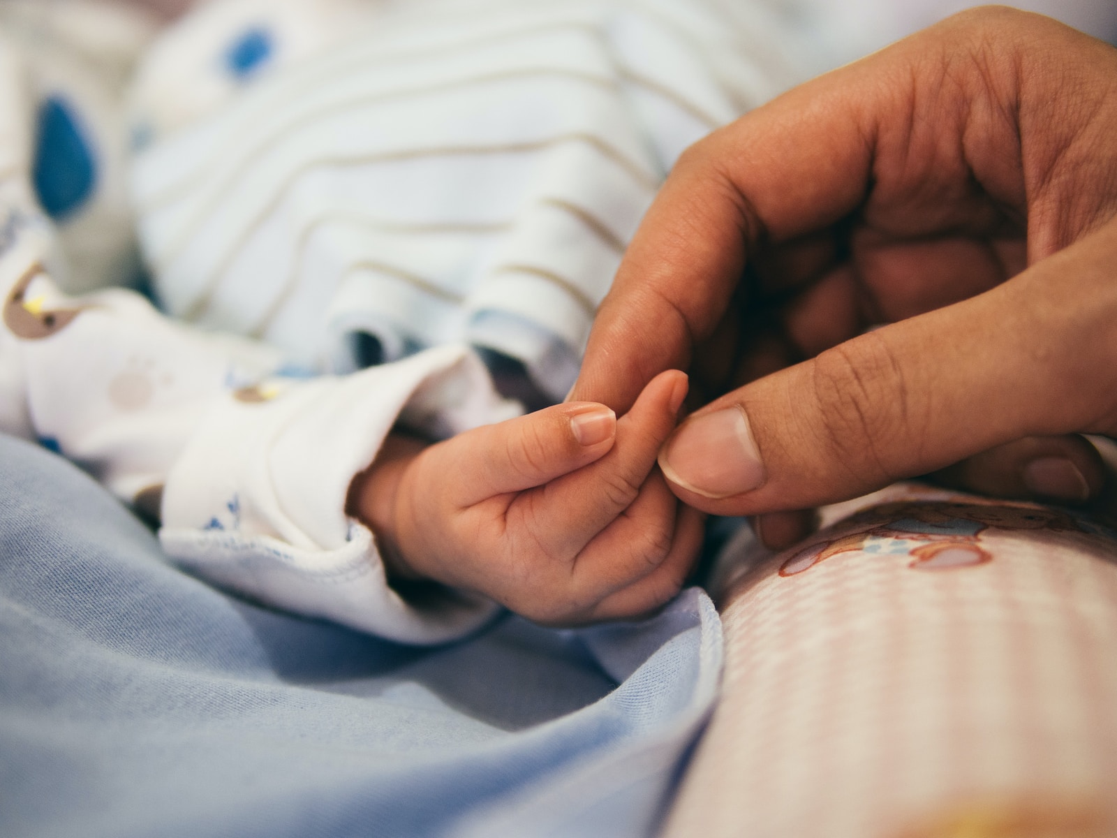 Photo par Aditya Romansa person holding baby's index finger